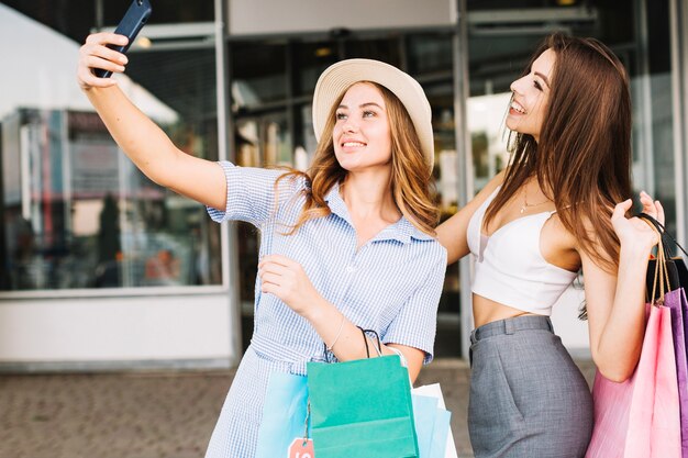 Joyeux amis prenant selfie dans un centre commercial