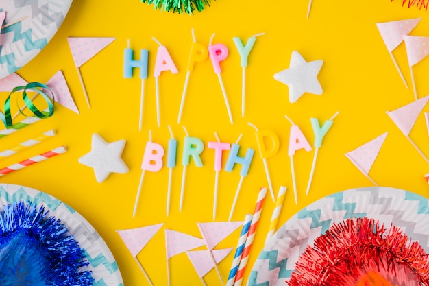 Photo gratuite joyeux anniversaire écrit au milieu des drapeaux et des assiettes