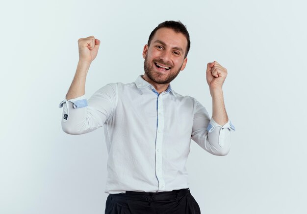 Joyeux bel homme garde les poings à la recherche d'isolement sur le mur blanc