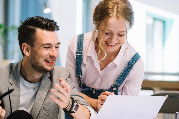 Joyeux collègues regardant des plans sur papier