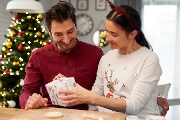 Photo gratuite joyeux couple avec cadeau de noël