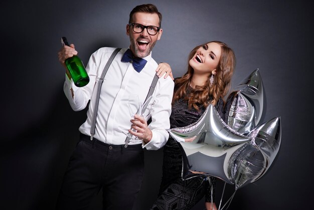 Joyeux couple avec champagne célébrant le nouvel an