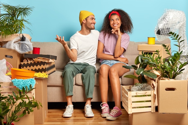 Joyeux couple marié souriant rêve d'un bel avenir dans leur nouvel appartement