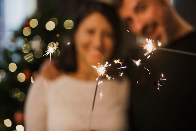 Joyeux couple de personnes âgées tenant un feu d'artifice