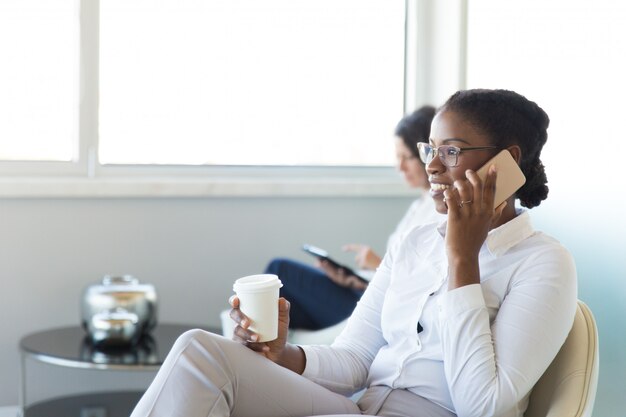 Joyeux employé de bureau parlant sur la cellule