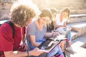 Photo gratuite joyeux étudiants étudient dans les escaliers