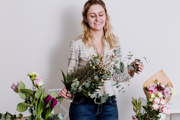 Photo gratuite joyeux fleuriste avec des grappes