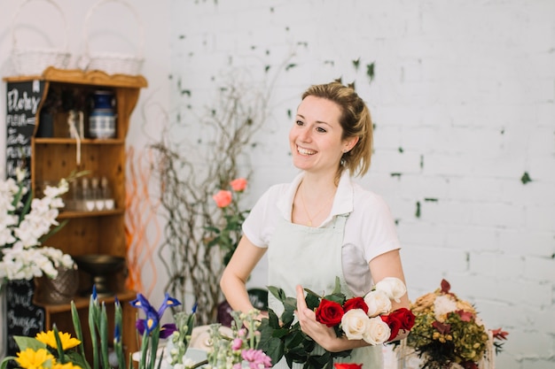 Joyeux fleuriste tenant le bouquet rose