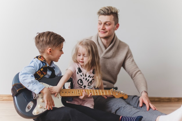 Joyeux garçon avec la guitare de son père