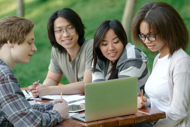 Joyeux groupe de jeunes étudiants assis et étudiant