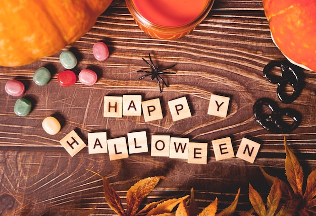 Joyeux halloween texte de blocs de bois, citrouilles, bougies, bonbons en arrière-plan