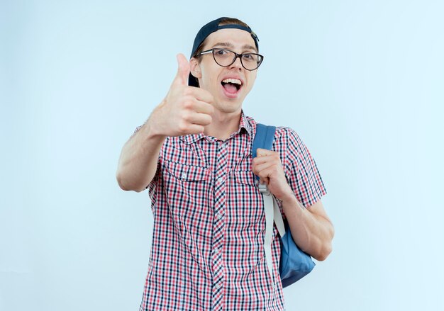 Joyeux jeune étudiant garçon portant un sac à dos et des lunettes et casquette son pouce vers le haut