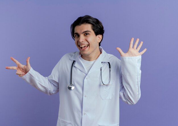 Joyeux jeune médecin de sexe masculin portant une robe médicale et un stéthoscope montrant huit avec les mains isolées sur le mur violet