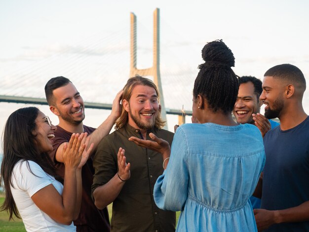 Joyeux jeunes faisant la surprise pour un ami. Femme afro-américaine présentant un muffin au chocolat avec sparkler. Concept de surprise