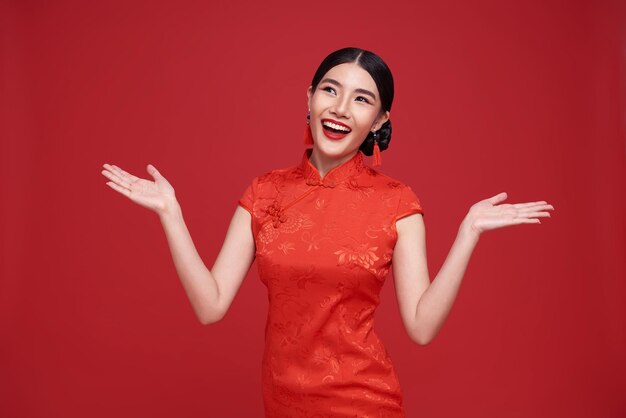 Joyeux nouvel an chinois femme asiatique vêtue d'une robe traditionnelle cheongsam qipao