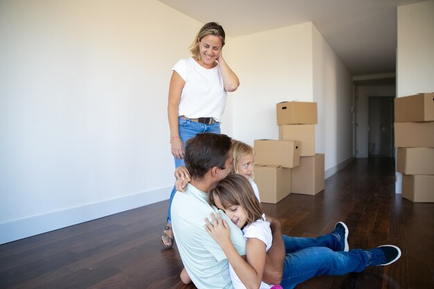 Joyeux parents et deux filles profitant de leur nouvelle maison