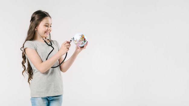 Junior avec stéthoscope et globe en studio