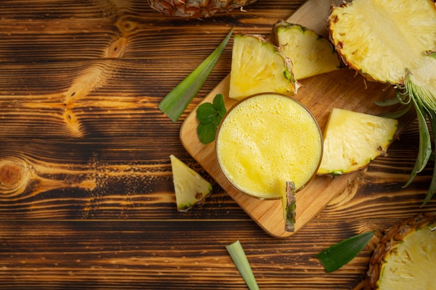 Jus d'ananas sur une surface en bois sombre