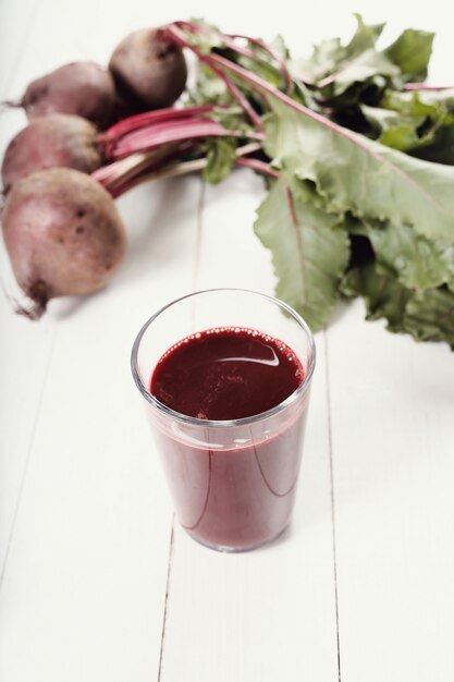 Jus de betterave rouge sur table en bois blanc