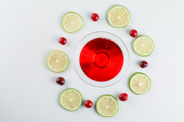 Photo gratuite jus de cerise aux cerises, tranches de citron dans un verre blanc