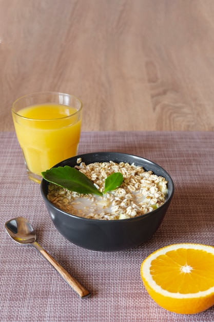 Photo gratuite jus d'orange avec un bol de gruau à l'avoine et une tranche d'orange