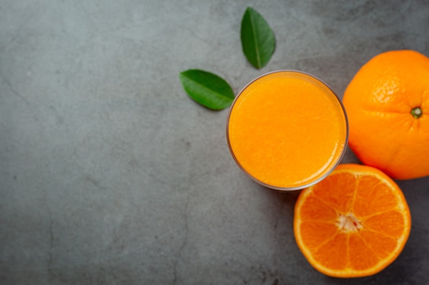 Jus d'orange frais dans le verre sur fond sombre