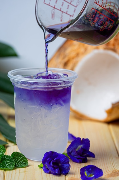 Jus de pois papillon à la noix de coco sur une surface en bois