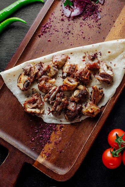 Kabab de viande servi avec épine-vinette et oignon