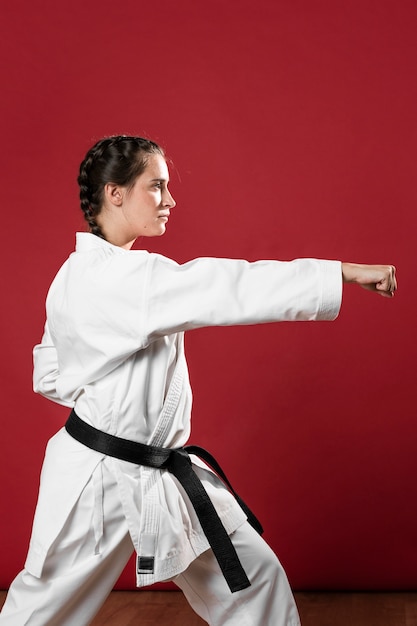 Karaté femme en action isolée sur fond rouge