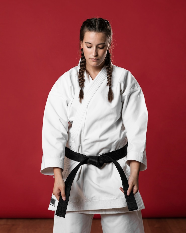 Photo gratuit karaté femme en kimono blanc traditionnel sur fond rouge