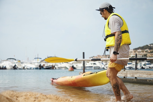 Kayak homme en casquette et veste de sécurité jaune