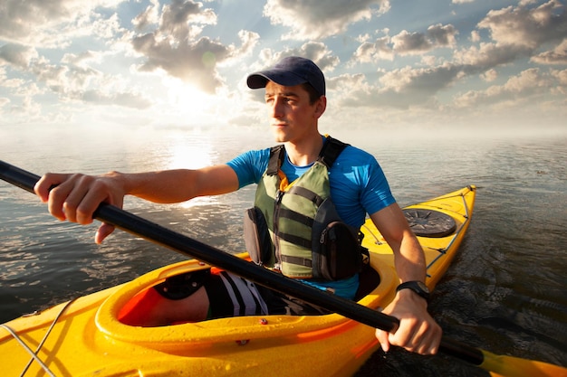 Photo gratuite kayak homme pagayant un kayak canoë-kayak