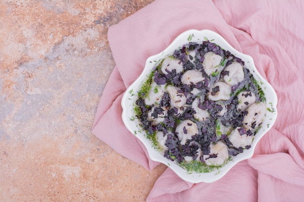 Khinkali caucasien non cuit dans un bol avec des herbes hachées