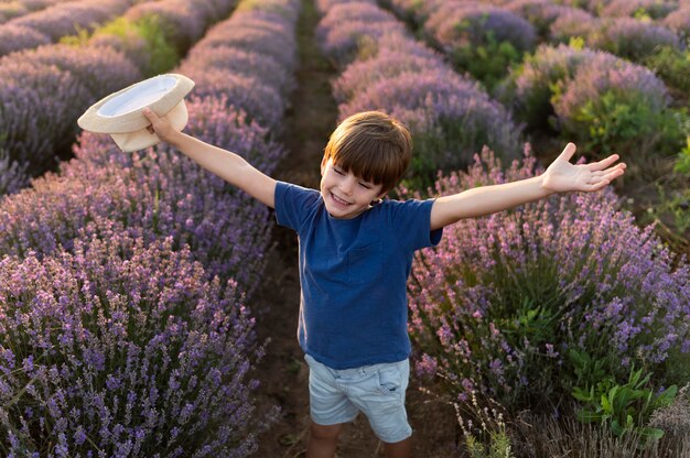 Kid à angle élevé dans le champ de fleurs