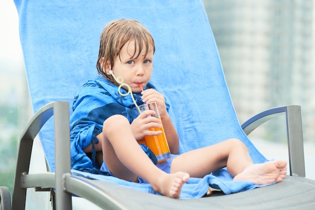 Kid boire du jus après la baignade