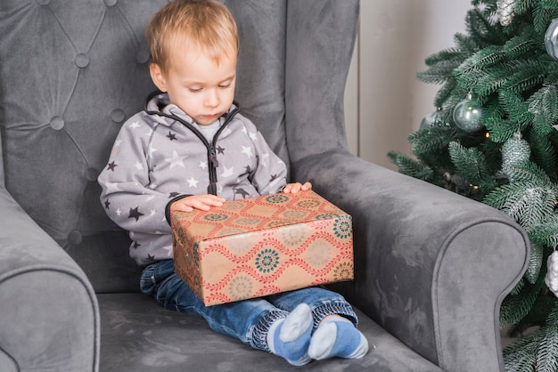 Photo gratuite kid sur le canapé avec boîte actuelle