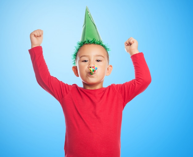 Kid avec un chapeau de fête et le ventilateur du parti