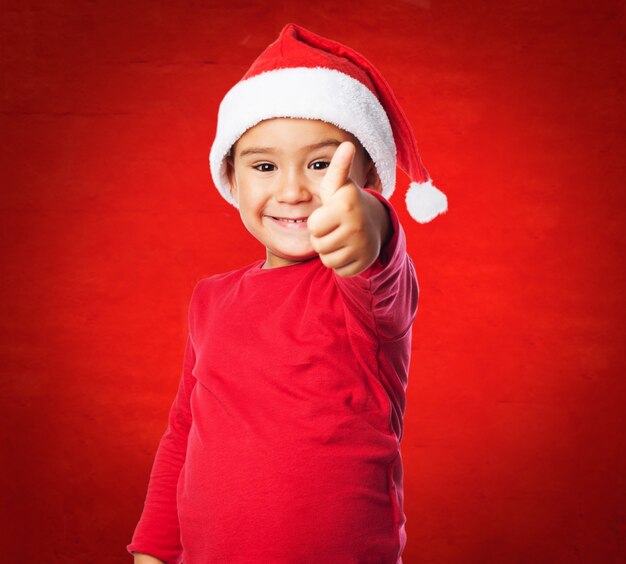 Kid avec le chapeau de sant et fond rouge