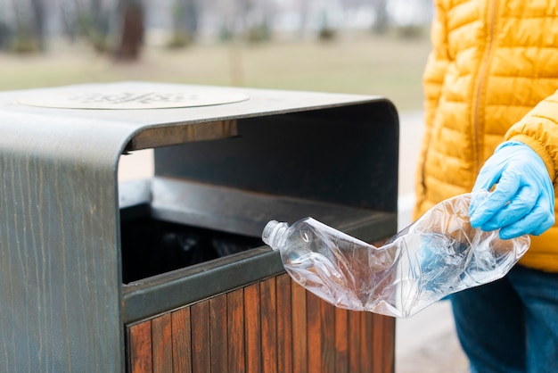 Kid jeter une bouteille en plastique dans la corbeille