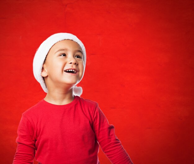 Kid avec le père noël chapeau regardant