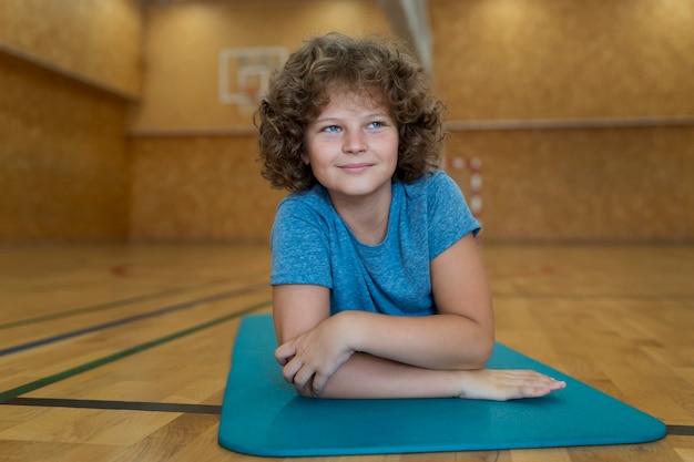 Kid Plein Coup Portant Sur Un Tapis De Yoga