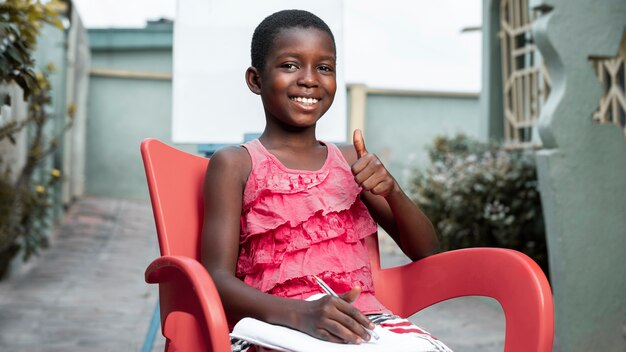 Kid shot moyen assis sur une chaise