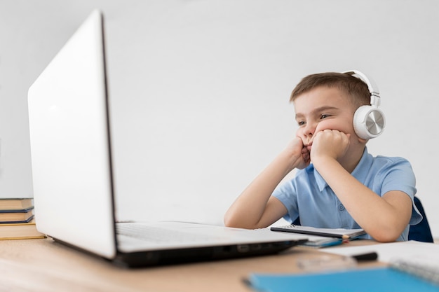 Kid shot moyen regardant un ordinateur portable