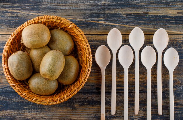 Kiwi Avec Des Cuillères Dans Un Panier En Osier Sur Fond En Bois, à Plat.