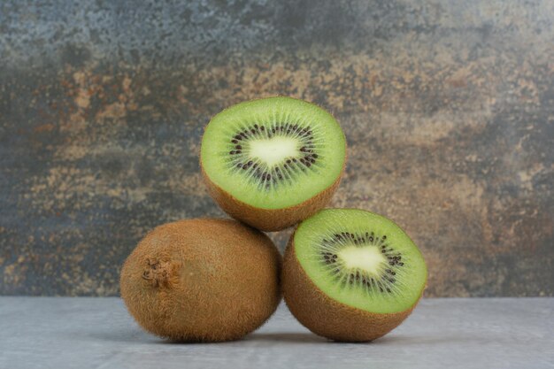 Kiwi mûr et tranches sur table en pierre. photo de haute qualité