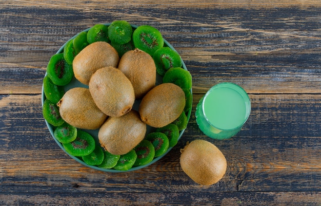 Kiwi avec des tranches séchées, boire dans un plateau sur fond en bois, poser à plat.