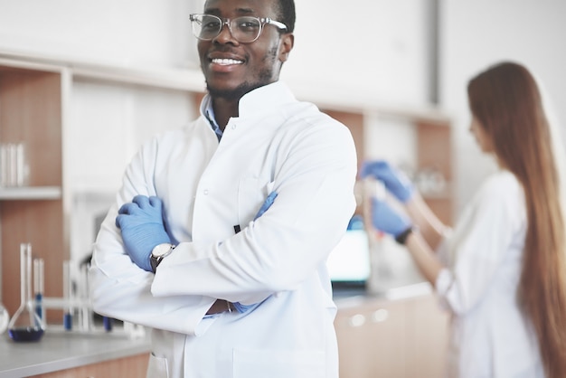 Les laboratoires de laboratoire mènent des expériences dans un laboratoire de chimie dans des flacons transparents. Formules de sortie.