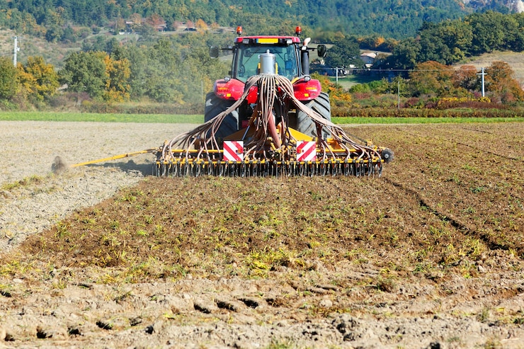 Photo gratuit labourer un tracteur lourd pendant la culture de l'agriculture travaille au champ avec charrue