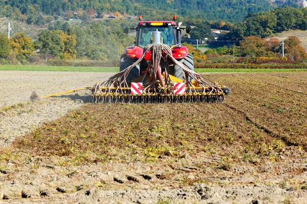 Labourer un tracteur lourd pendant la culture de l'agriculture travaille au champ avec charrue