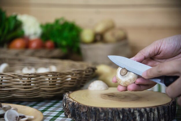 Lady cuisine des légumes champignons frais au champignon dans la cuisine